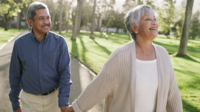 4k video footage of a happy senior couple going for a relaxing walk in the park