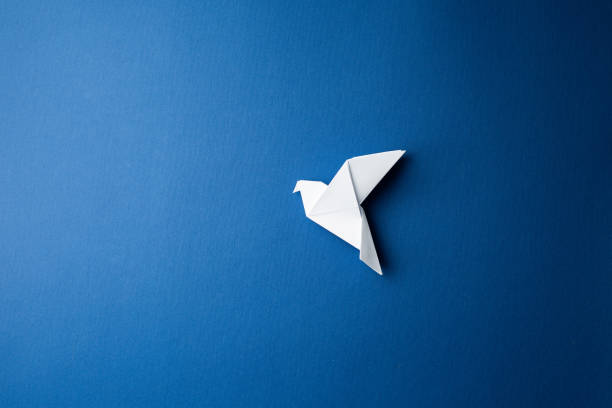 istock Paper pigeon on a blue isolated background. 1214154407