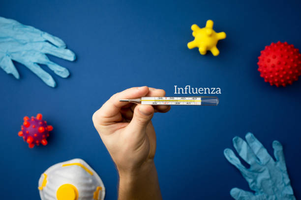 istock Hand with medical thermometer virus concept model. 1214155075