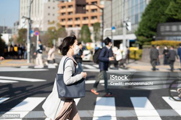 Businesswoman With Surgical Mask Walking In City Stock Photo - Download Image Now - Japan, City, Commuter