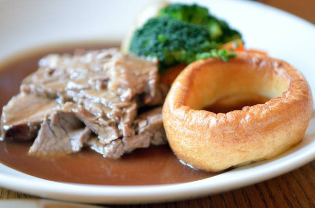 traditional sunday roast beef dinner with yorkshire puddings and gravy - yorkshire pudding imagens e fotografias de stock