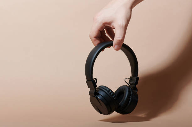 istock Hand hold black wireless headphones 1214159816