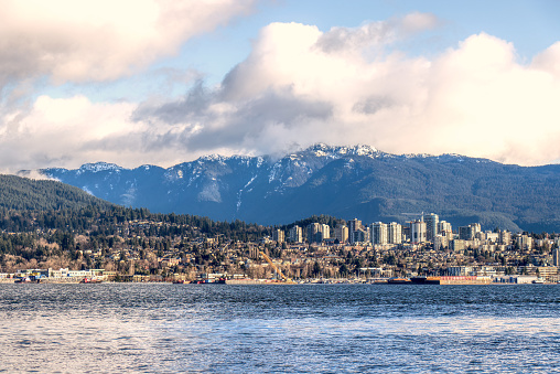 View of North Vancouver with mointains and massive clouds in the background at sunny day