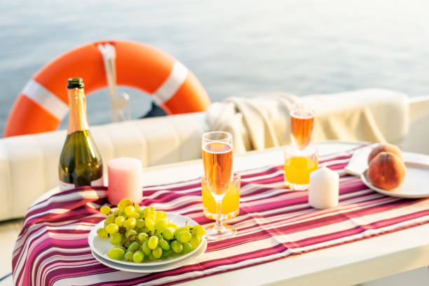 petit déjeuner ou dîner romantique sur un yacht à moteur. la lumière du soleil dure. - beach table peach fruit photos et images de collection