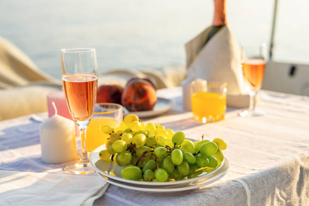 colazione romantica o cena su uno yacht a motore. luce del sole dura. - beach table peach fruit foto e immagini stock