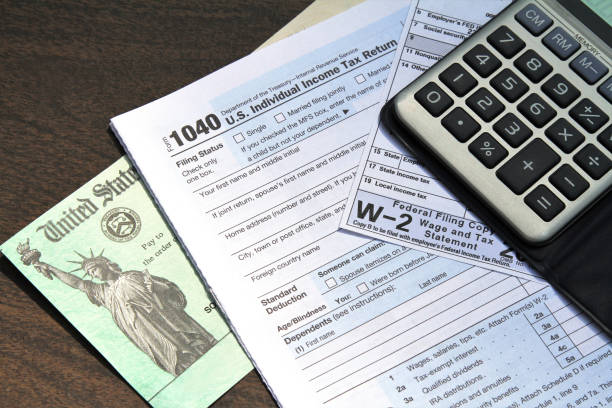 財務省の小切手と電卓を含む税務フォーム - w2 ストックフォトと画像