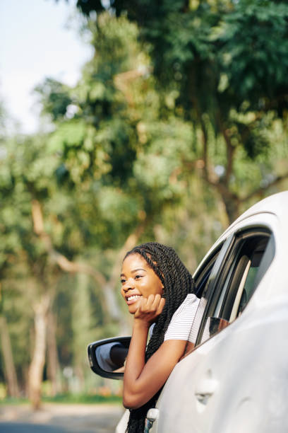 istock Dreamy young woman in her car 1214165980