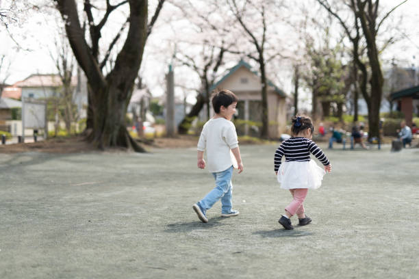 istock Siblings walking to cherry trees in park 1214171590