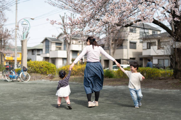 madre e hijos jugando frente a los cerezos - child dancing preschooler outdoors fotografías e imágenes de stock
