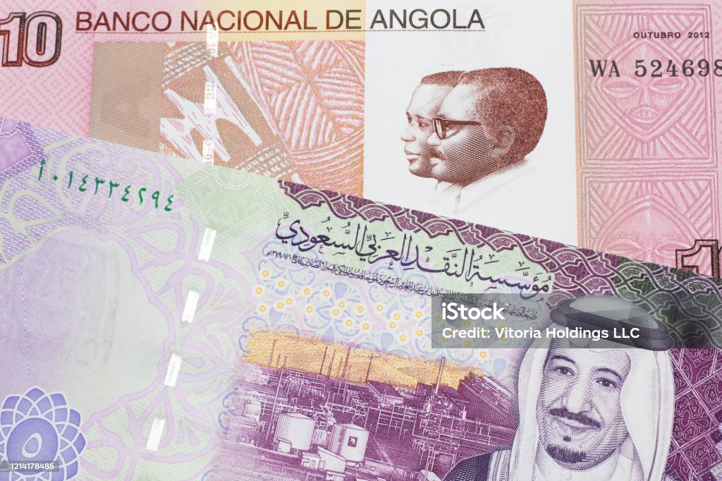 Colorful currency from Angola with Saudi Arabian money A colorful ten kwanza bill from Angola with a colorful, Saudi Arabian riyal bank note close up in macro Africa Stock Photo