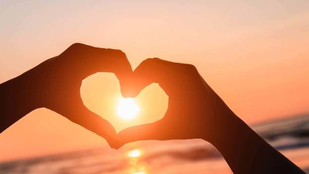 istock sugn hand at the sea sunset orange background 1214179200