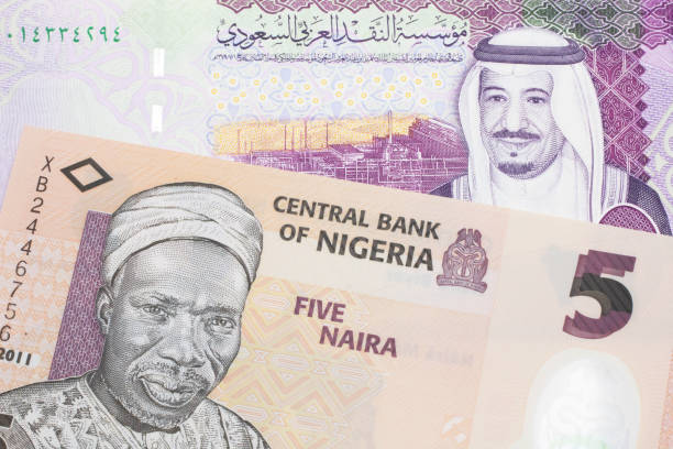 A Nigerian naira bill with with a five Saudi riyal bank note close up stock photo