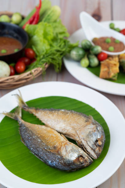 istock Fried mackerel placed on a white plate on a wooden floor. 1214180832