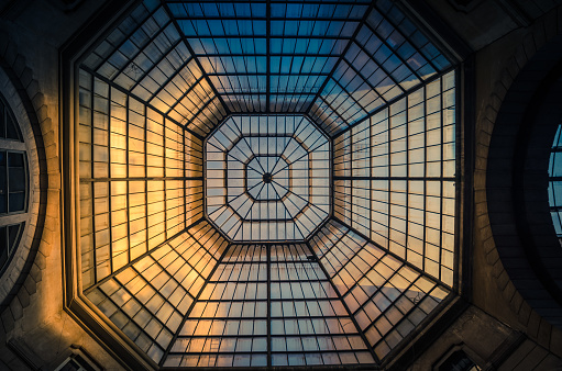 Milan, Italy, September 8, 2018: Glass and iron patterned ceiling roof of huge dome of shopping mall, view from below, Milano city
