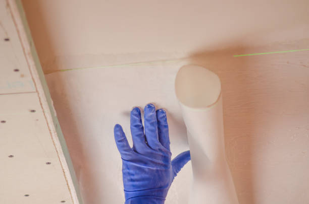 istock The Builder puts plaster on the wall.Hand holding a spatula with construction mix and smoothes out bumps.Repair the wall.Plaster the wall with a putty knife. 1214188860