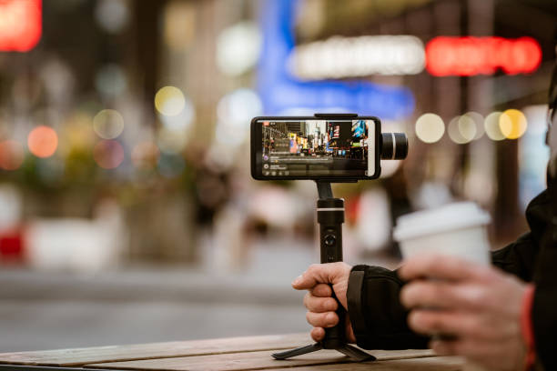 istock Man taking photos and videos with phone and stabilizer 1214189098