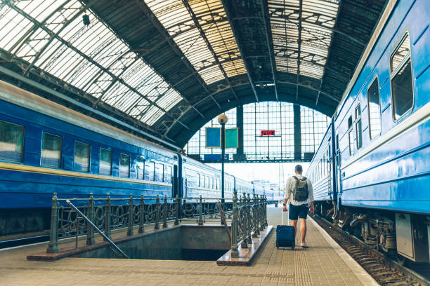 istock man walking with suitcase on wheel by railway station 1214192230