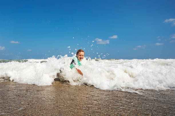 istock Little boy playing and splashing in sea 1214193699