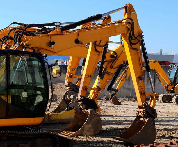 istock Excavator booms and buckets lined up in a construction site. 1214195274
