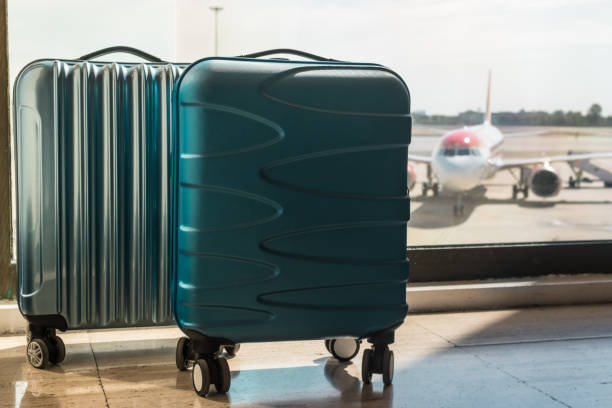 istock blue cabin suitcases at the airport with plane background 1214196155