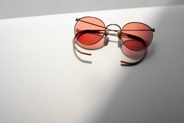 istock Beautiful red vintage glasses on a modern grey tablet with sunlight 1214198695