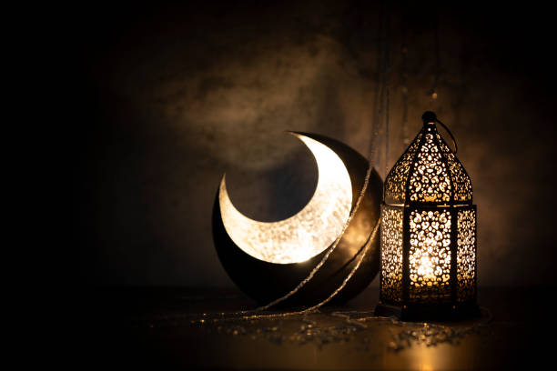 istock Dark photography of a crescent moon and a lantern with a dim lighting effect. 1214199698