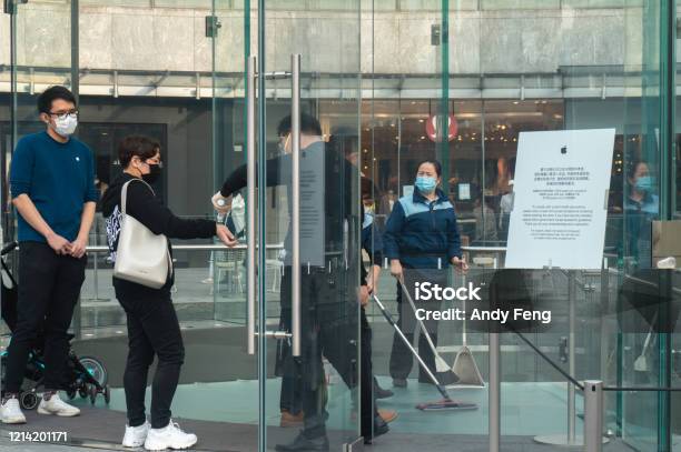 Shanghai China Mar 22 2020 At One Of The Biggest Apple Store In Shanghai Lujiazui The Staff Is Screening The Temperature Of A Customers With Face Mask At The Entrance During The 2019ncov Stock Photo - Download Image Now