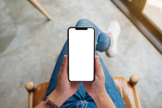 istock a woman holding mobile phone with blank white screen 1214202403