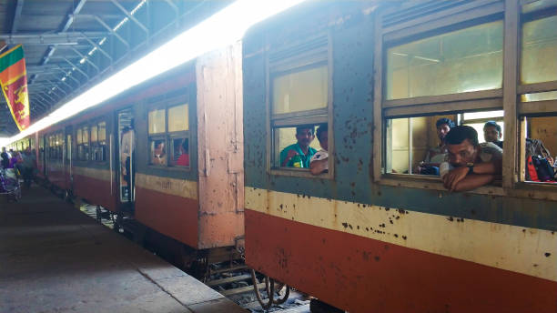Sad people peep out of the windows of an old rusty train car. Sri Lanka Railway Station Sad people peep out of the windows of an old rusty train car. Sri Lanka Railway Station. colombo train stock pictures, royalty-free photos & images