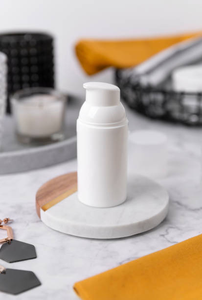 istock Cosmetic bottle containers with yellow towels and accessories on marble table 1214203417