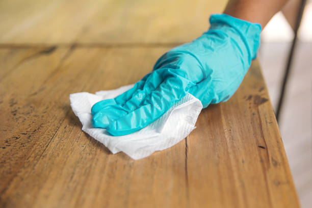 Wiping table surface regularly with disinfectant to kill virus Close up shot female hands wiping table surface in precautions of Coronavirus surface disinfection stock pictures, royalty-free photos & images