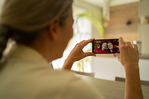 mujer hija adulta conectada con sus padres mayores a través de videollamada de teléfono móvil durante la crisis del coronavirus photo