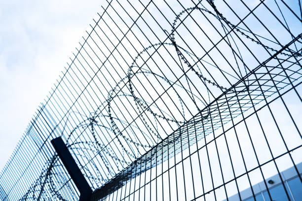 istock Barbed wire mesh fence. Close-up. Passage is limited 1214209886