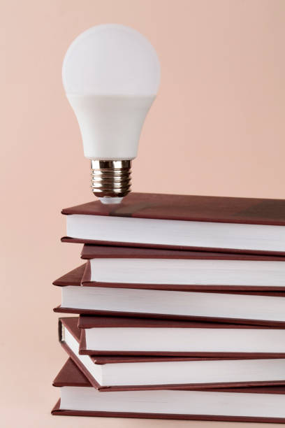 istock Stack of books and lamp idea on brown background education concept. 1214211991