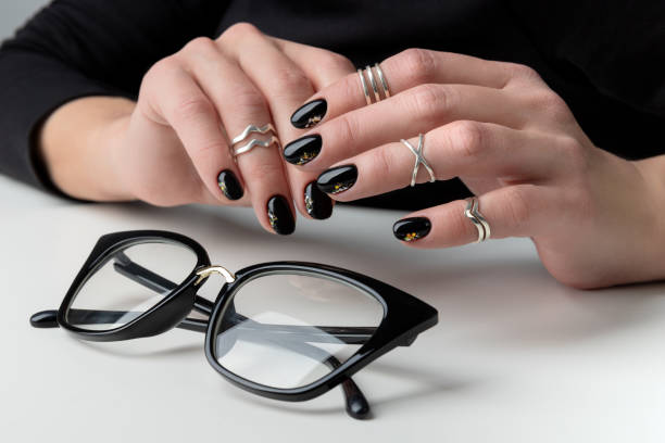 Beautiful womans hand with elegant manicure. Minimal black nail design.