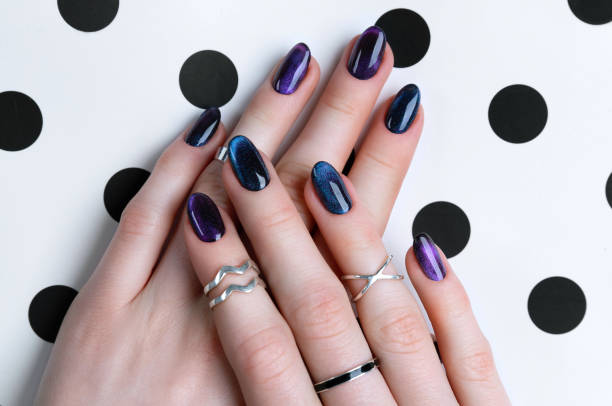 istock Beautiful groomed woman's hands with dark glitter polish design on nails 1214215572