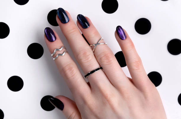 Beautiful groomed woman's hands with dark glitter polish design on nails