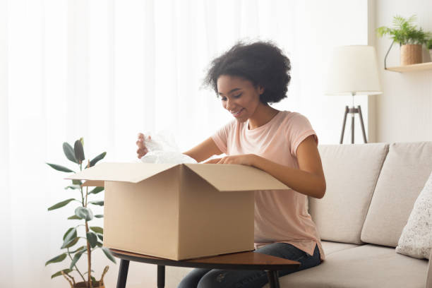 istock Glad girl opens buying sitting on the couch 1214220262