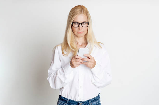 istock Mature woman reading message on her phone 1214220667