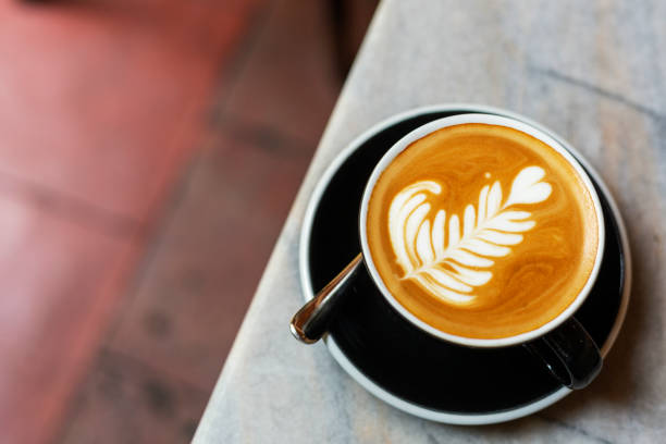 istock Top view of cappuccino in coffe cup with latte art on table 1214220956