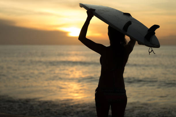 istock Surfer woman carrying surfboard at the beach 1214222028