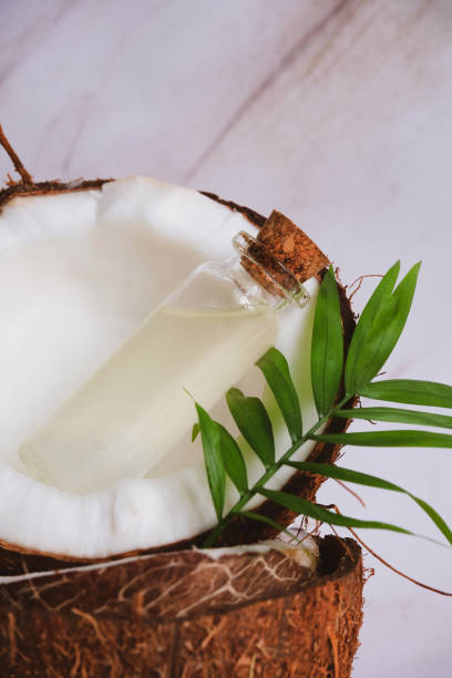 istock selective focus glass bottles with coconut oil on a blurred background of cracked coconuts and palm leaves 1214222064