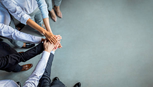 istock Unrecognizable Coworkers Holding Hands Standing In Office, Cropped, Above View 1214222484