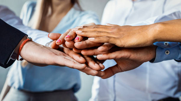 istock Unrecognizable Colleagues Holding Hands In Circle In Office, Panorama, Closeup 1214222489