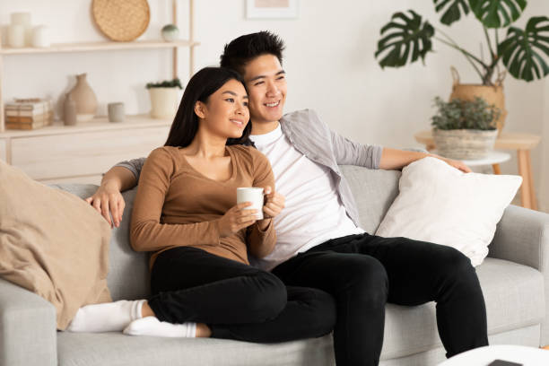 Filipino couple resting at home and watching tv Home Weekend. Lovely filipino couple watching film resting on a couch at home, copy space hot filipina women stock pictures, royalty-free photos & images