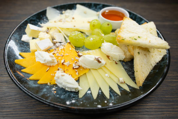 istock assorted cheese. thin sliced ​​cheese with grapes crispy croutons of white bread with honey and walnuts 1214222993