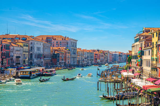 paisaje urbano de venecia con canal del gran canal. vista desde el puente de rialto. góndolas, barcos, vaporettos atracados y vela canal grande. arquitectura veneciana edificios coloridos. región del véneto, italia. - venice italy rialto bridge italy gondola fotografías e imágenes de stock