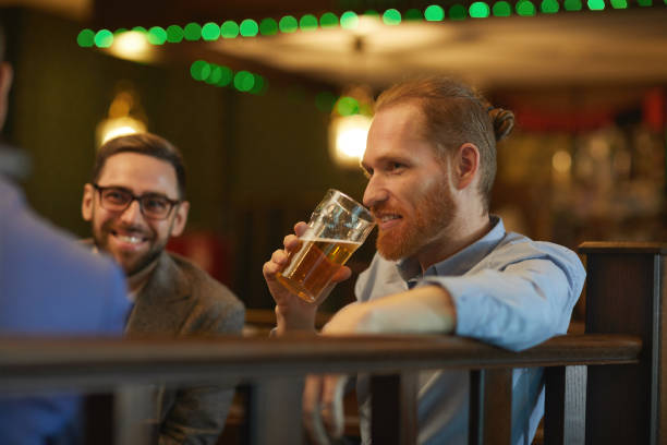 istock Man drinking beer with friends 1214223846