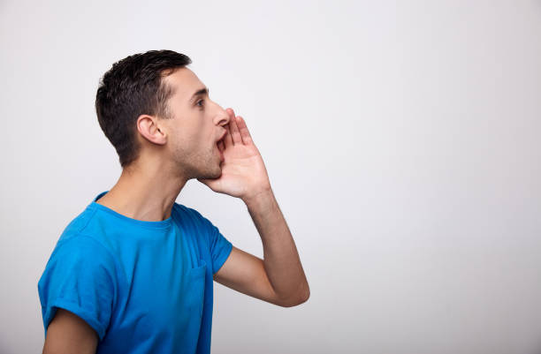 istock A young man shouts standing against a white background. 1214224670