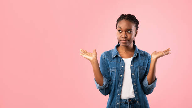 istock Puzzled Girl Holding Two Invisible Objects Choosing Over Pink Background 1214225680